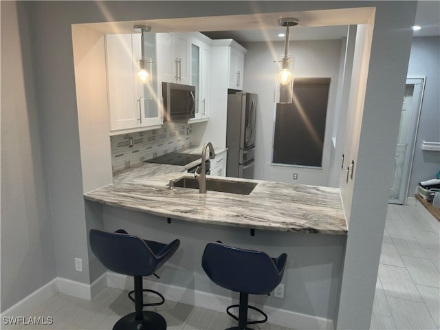 8241 Pacific Beach Dr, Fort Myers, FL 33966 - kitchen featuring stainless steel appliances, decorative backsplash, white cabinetry, and light stone counters