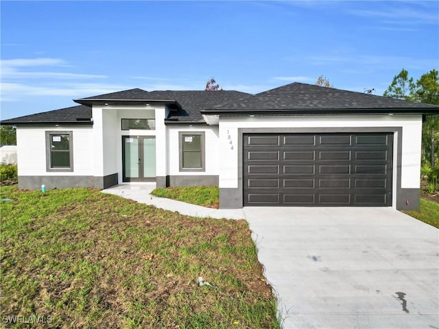2616 42nd St W, Lehigh Acres, FL 33971 - view of front of property featuring french doors, an attached garage, concrete driveway, and roof with shingles