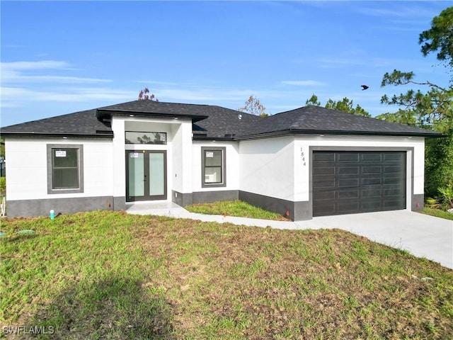 2616 42nd St W, Lehigh Acres, FL 33971 - view of front facade featuring french doors, an attached garage, concrete driveway, a front yard, and stucco siding