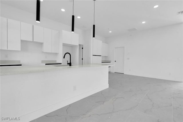 2616 42nd St W, Lehigh Acres, FL 33971 - kitchen with white cabinets, light marble finish flooring, modern cabinets, recessed lighting, and light countertops