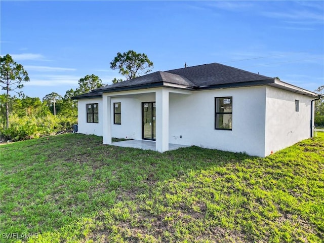 2616 42nd St W, Lehigh Acres, FL 33971 - rear view of property with stucco siding, a yard, a patio, and a shingled roof