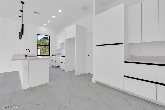 2616 42nd St W, Lehigh Acres, FL 33971 - kitchen with modern cabinets, light marble finish flooring, white cabinets, and recessed lighting