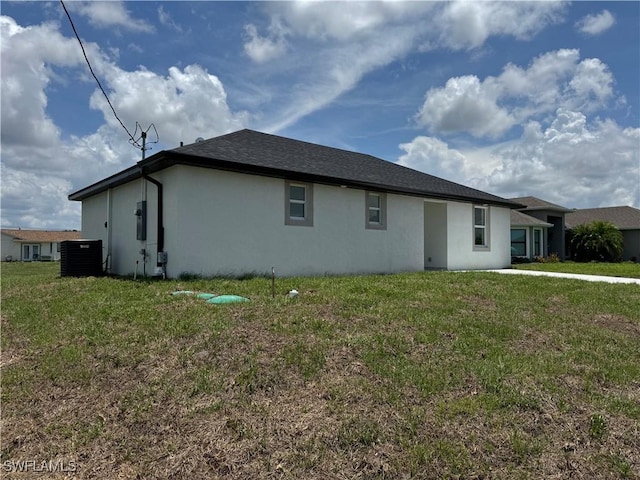 2902 27th St SW, Lehigh Acres, FL 33976 - back of house featuring stucco siding and a yard