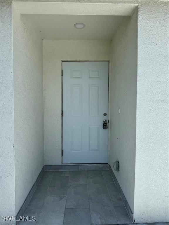 2902 27th St SW, Lehigh Acres, FL 33976 - property entrance featuring stucco siding