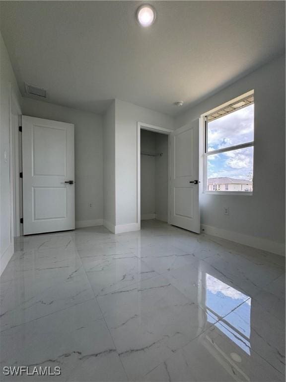 2902 27th St SW, Lehigh Acres, FL 33976 - unfurnished bedroom with light marble finish flooring, a closet, and recessed lighting