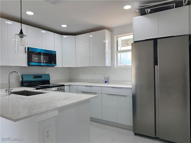 2902 27th St SW, Lehigh Acres, FL 33976 - kitchen with stainless steel appliances, a peninsula, modern cabinets, white cabinets, and recessed lighting
