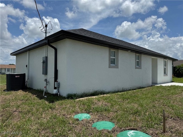 2902 27th St SW, Lehigh Acres, FL 33976 - view of side of home with stucco siding, a lawn, and roof with shingles