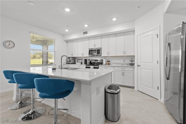 14818 Birchwood Ct Unit 6412, Punta Gorda, FL 33955 - kitchen featuring appliances with stainless steel finishes, light tile patterned flooring, a breakfast bar area, recessed lighting, and an island with sink