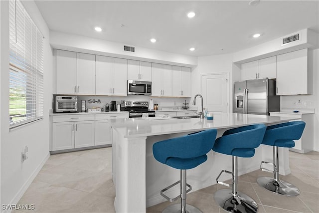14818 Birchwood Ct Unit 6412, Punta Gorda, FL 33955 - kitchen featuring stainless steel appliances, a kitchen bar, white cabinetry, and recessed lighting