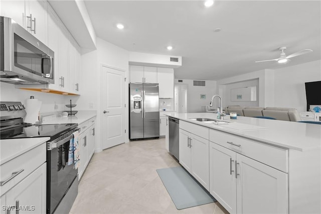 14818 Birchwood Ct Unit 6412, Punta Gorda, FL 33955 - kitchen featuring stainless steel appliances, white cabinets, light countertops, ceiling fan, and a center island with sink