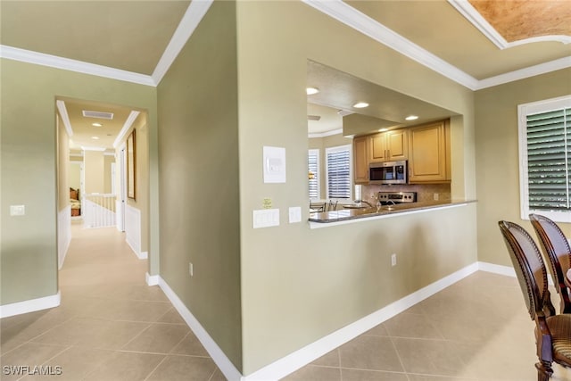 713 Regency Reserve Cir Unit 5903, Naples, FL 34119 - kitchen with stainless steel microwave, ornamental molding, light tile patterned flooring, light brown cabinetry, and decorative backsplash