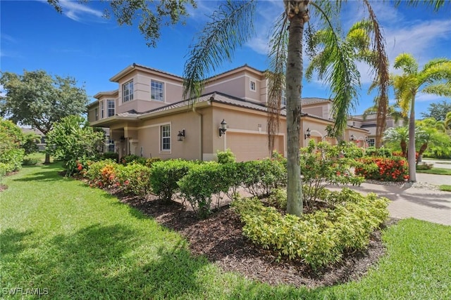 713 Regency Reserve Cir Unit 5903, Naples, FL 34119 - view of side of home with stucco siding, a yard, an attached garage, and driveway