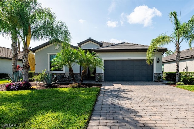 17573 Ashcomb Way, Estero, FL 33928 - ranch-style home featuring decorative driveway, an attached garage, stucco siding, and a front yard