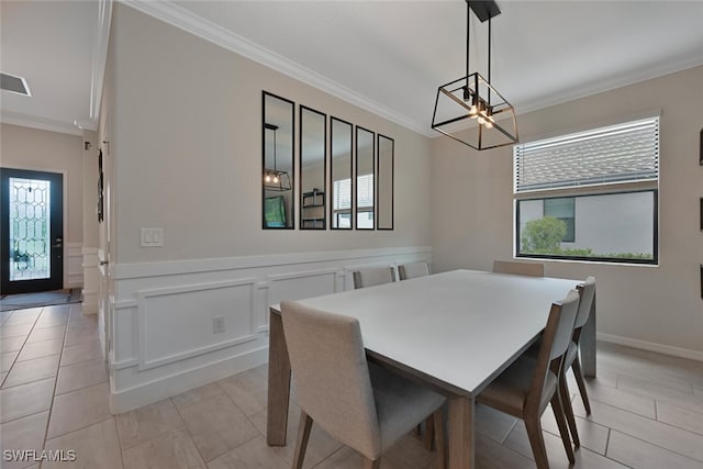 17573 Ashcomb Way, Estero, FL 33928 - dining room with ornamental molding, a chandelier, plenty of natural light, light tile patterned floors, and a wainscoted wall