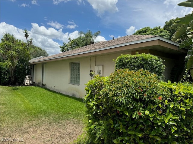 9973 Boca Ave N, Naples, FL 34109 - view of side of property featuring stucco siding and a lawn