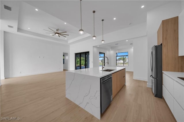 1502 SW 17th Ave, Cape Coral, FL 33991 - kitchen featuring modern cabinets, freestanding refrigerator, dishwasher, light wood-type flooring, and a center island with sink