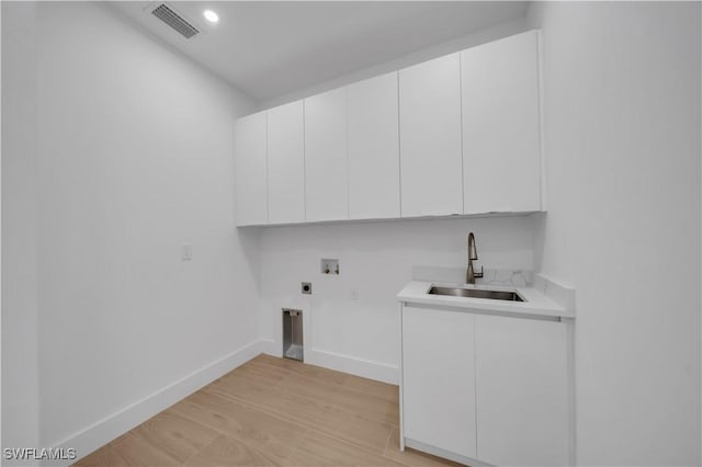 1502 SW 17th Ave, Cape Coral, FL 33991 - washroom with hookup for a washing machine, hookup for an electric dryer, cabinet space, and light wood-style flooring