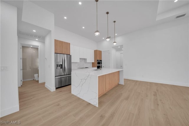 1502 SW 17th Ave, Cape Coral, FL 33991 - kitchen with stainless steel refrigerator with ice dispenser, modern cabinets, light wood finished floors, pendant lighting, and recessed lighting