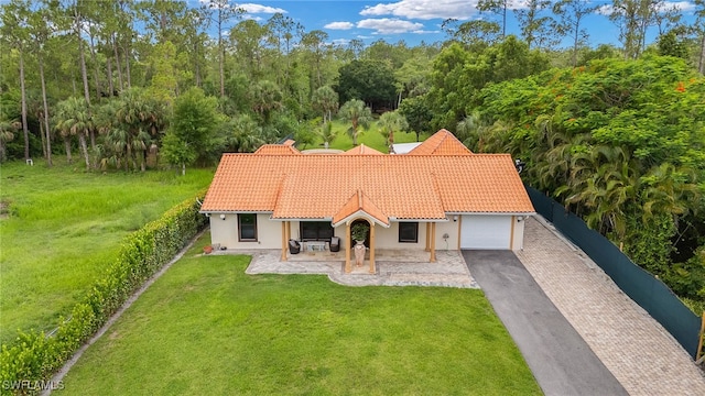 3270 14th Ave NE, Naples, FL 34120 - mediterranean / spanish-style home featuring a tiled roof, an attached garage, driveway, and stucco siding