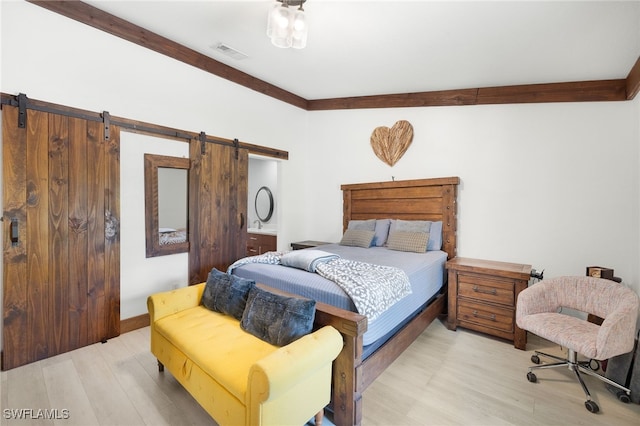 3270 14th Ave NE, Naples, FL 34120 - bedroom with a barn door and light wood-style flooring