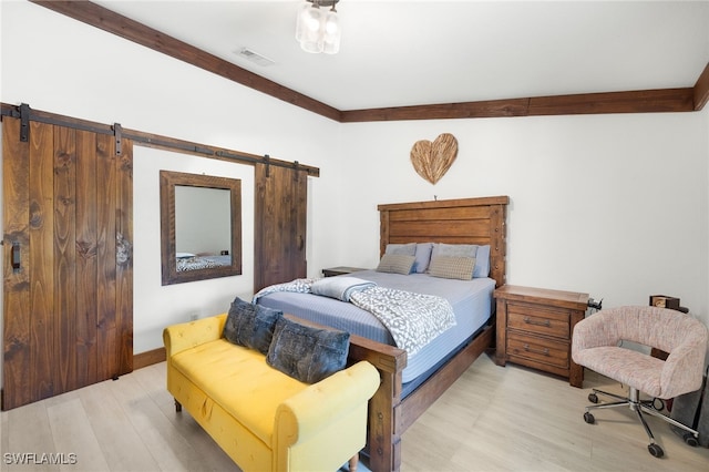 3270 14th Ave NE, Naples, FL 34120 - bedroom with a barn door and light wood-style floors