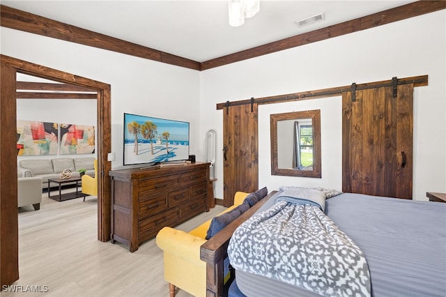 3270 14th Ave NE, Naples, FL 34120 - bedroom with a barn door and light wood-style floors