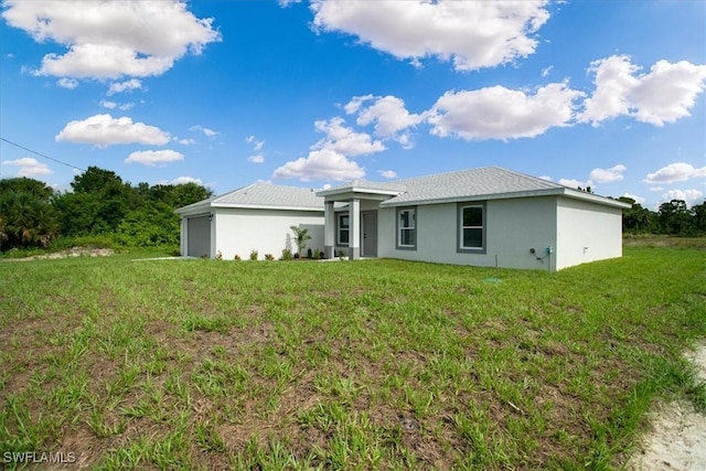 3010 62nd St W, Lehigh Acres, FL 33971 - rear view of property featuring a garage, stucco siding, and a lawn