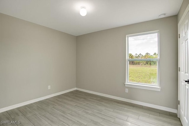 3010 62nd St W, Lehigh Acres, FL 33971 - empty room with healthy amount of natural light, a smoke detector, and light wood finished floors