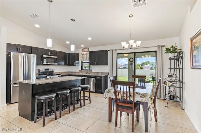 2619 42nd St SW, Lehigh Acres, FL 33976 - kitchen featuring stainless steel appliances, a chandelier, vaulted ceiling, plenty of natural light, and a center island