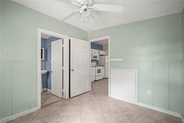 751 108th Ave N, Naples, FL 34108 - spare room with a decorative wall, a ceiling fan, light tile patterned floors, and a wainscoted wall