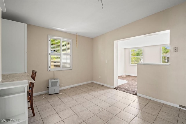 751 108th Ave N, Naples, FL 34108 - unfurnished room featuring healthy amount of natural light and light tile patterned flooring