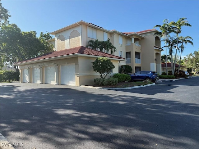 1520 SW 50th St Unit 101, Cape Coral, FL 33914 - view of front of house featuring stucco siding, a garage, driveway, and a tiled roof