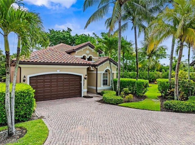 5757 Mango Cir Unit 5757, Naples, FL 34110 - mediterranean / spanish-style house featuring an attached garage, stucco siding, driveway, and a tiled roof