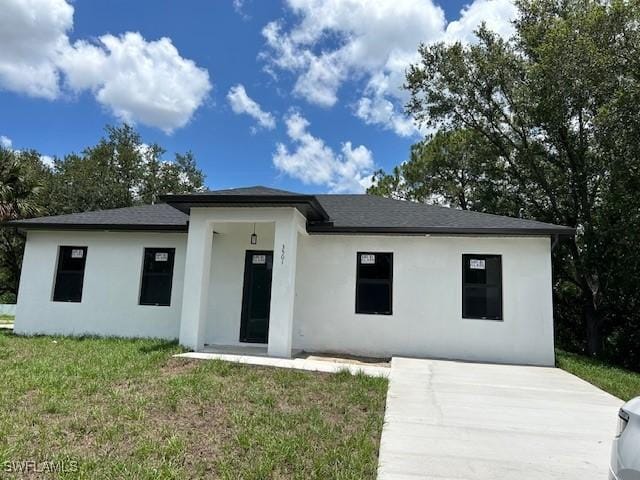 3501 E 10th St, Lehigh Acres, FL 33972 - prairie-style house with stucco siding, a front yard, and driveway