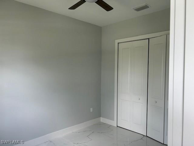 3501 E 10th St, Lehigh Acres, FL 33972 - unfurnished bedroom with light marble finish flooring, a closet, and ceiling fan