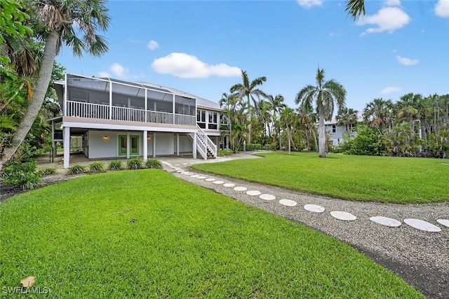 6120 Henderson Rd, Sanibel, FL 33957 - back of house with a sunroom, a yard, stairs, and a wooden deck