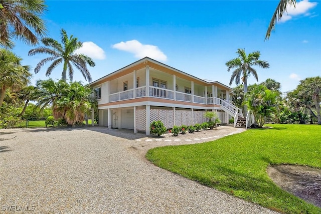 6120 Henderson Rd, Sanibel, FL 33957 - beach home featuring covered porch, a garage, a front lawn, driveway, and stairs