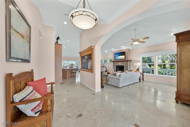 6120 Henderson Rd, Sanibel, FL 33957 - living room with crown molding, a ceiling fan, a tiled fireplace, arched walkways, and recessed lighting