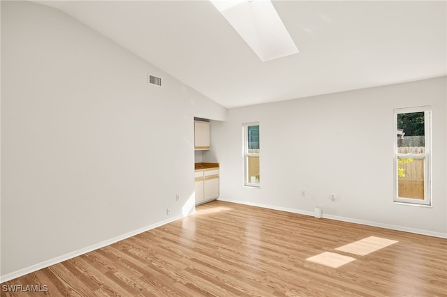 19897 Midway Blvd, Port Charlotte, FL 33948 - empty room featuring a skylight, healthy amount of natural light, light wood finished floors, and high vaulted ceiling