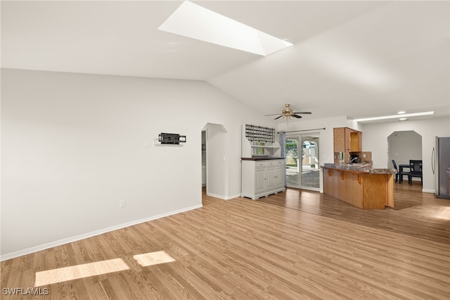 19897 Midway Blvd, Port Charlotte, FL 33948 - unfurnished living room featuring light wood-type flooring, a skylight, ceiling fan, vaulted ceiling, and arched walkways