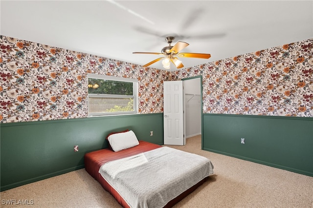 19897 Midway Blvd, Port Charlotte, FL 33948 - carpeted bedroom featuring wallpapered walls, a wainscoted wall, a ceiling fan, a walk in closet, and a closet