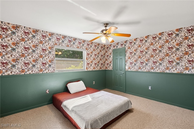 19897 Midway Blvd, Port Charlotte, FL 33948 - carpeted bedroom featuring wainscoting, wallpapered walls, and a ceiling fan