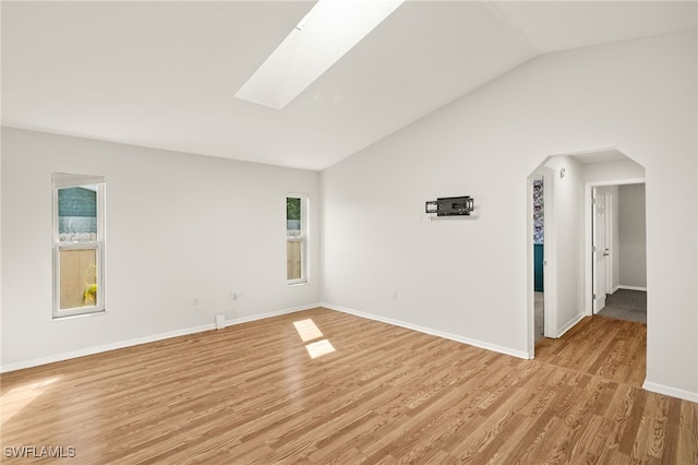 19897 Midway Blvd, Port Charlotte, FL 33948 - spare room with lofted ceiling, light wood-style flooring, a skylight, and arched walkways