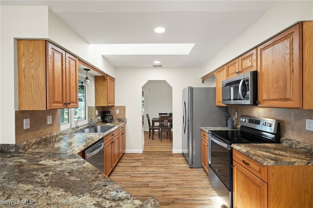 19897 Midway Blvd, Port Charlotte, FL 33948 - kitchen featuring appliances with stainless steel finishes, light wood-type flooring, backsplash, arched walkways, and recessed lighting