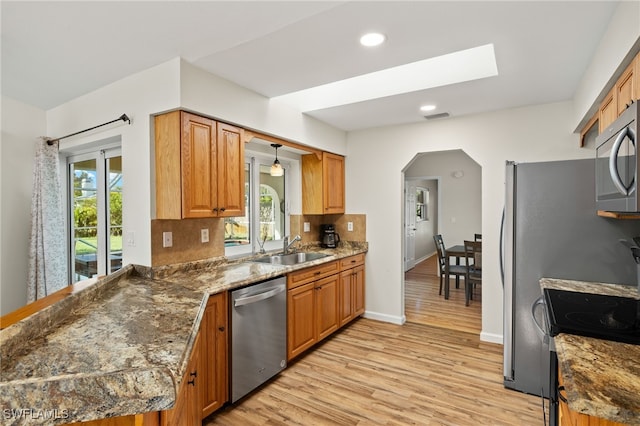 19897 Midway Blvd, Port Charlotte, FL 33948 - kitchen with stainless steel appliances, arched walkways, light wood-style flooring, recessed lighting, and tasteful backsplash