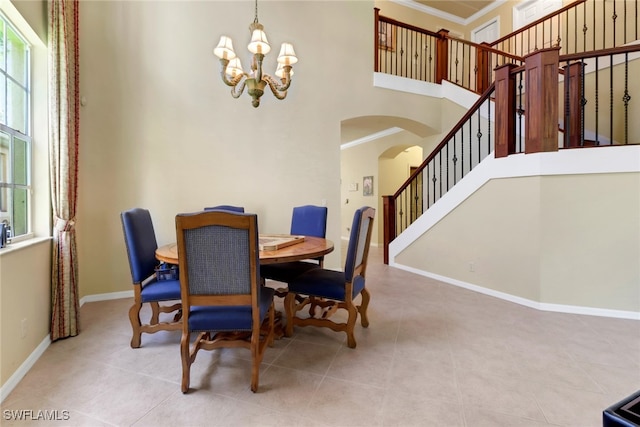 5730 Lago Villaggio Way, Naples, FL 34104 - tiled dining room featuring arched walkways, ornamental molding, a chandelier, a high ceiling, and stairway