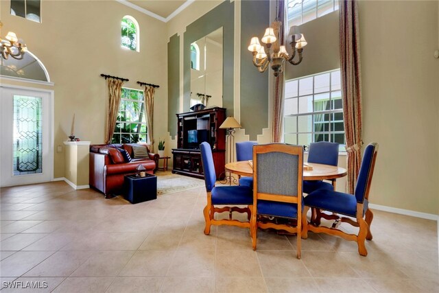 5730 Lago Villaggio Way, Naples, FL 34104 - dining area featuring a chandelier, a high ceiling, healthy amount of natural light, tile patterned floors, and crown molding