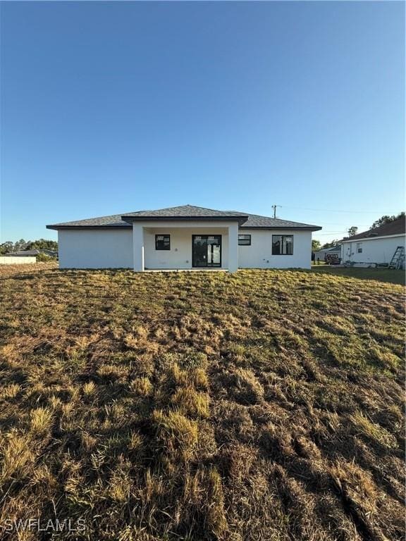3206 28th St SW, Lehigh Acres, FL 33976 - rear view of property featuring a lawn