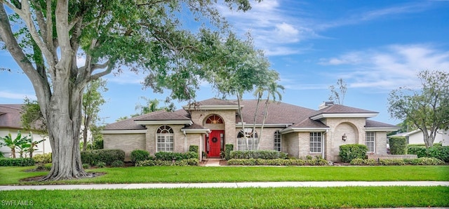 41 Timberland Cir S, Fort Myers, FL 33919 - mediterranean / spanish house with a front yard, brick siding, and roof with shingles