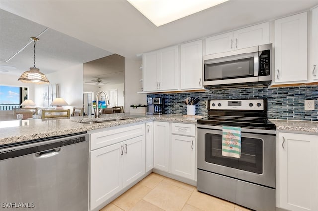 400 E Lenell Unit 110, Fort Myers Beach, FL 33931 - kitchen with appliances with stainless steel finishes, white cabinetry, tasteful backsplash, light tile patterned floors, and light stone counters